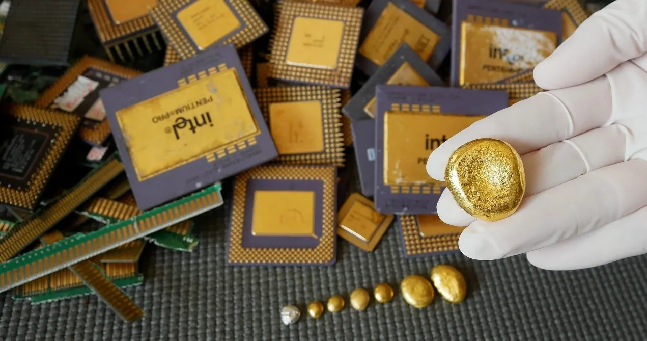 Gold recovered from old computer processors held in a gloved hand